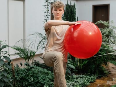 Man performing a balancing exercise on one leg in a calm environment.